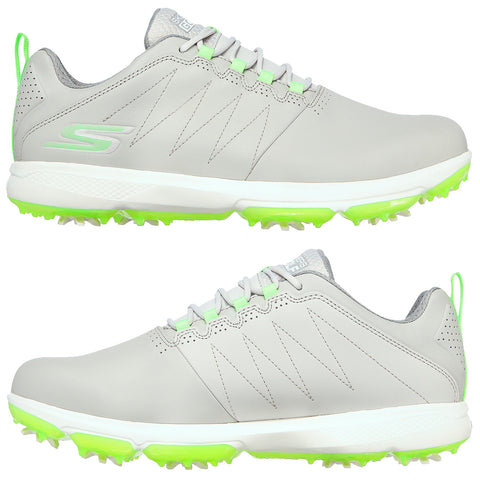 Gray golf shoes with green accents are displayed side by side. They feature a smooth surface, prominent laces, and spikes on the soles designed for traction on the golf course.