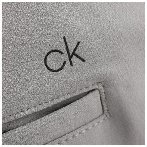 A gray fabric features a small black logo reading ck located above a stitched pocket indicating a minimalist design typical of contemporary fashion items.