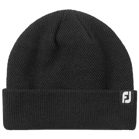 A black knit beanie is displayed lying flat it features a folded cuff and a small logo tag on the side showcasing a simple and warm winter accessory.