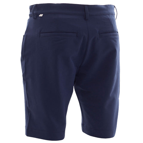 Dark navy shorts are displayed with a focus on the back view featuring a flat waistband and two back pockets in an indoor setting with neutral lighting.