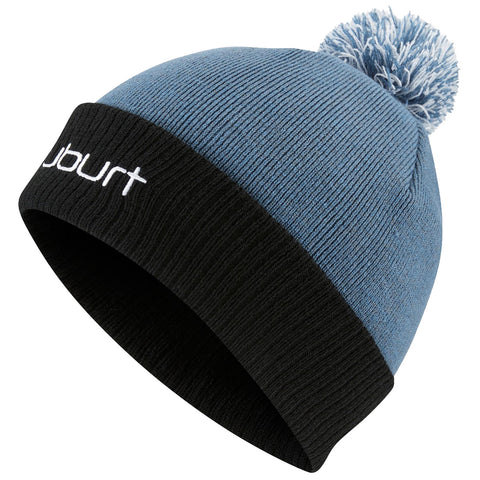 A blue and black knit beanie with a pom-pom sits at an angle showcasing its textured fabric and white brand logo on the black cuff, suitable for casual cold weather wear.
