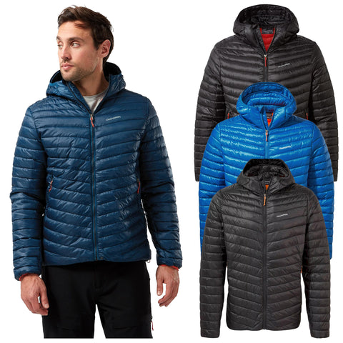 A man is wearing a blue puffy jacket with a hood displaying a zipper and side pockets while three additional jackets in black and blue hang beside him in a showroom.