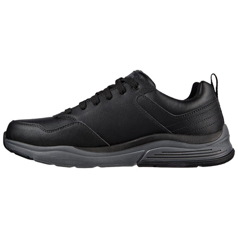 A black sneaker with a smooth leather upper and a cushioned sole sits upright showcasing its lace-up design and contrasting gray outsole in a plain background.