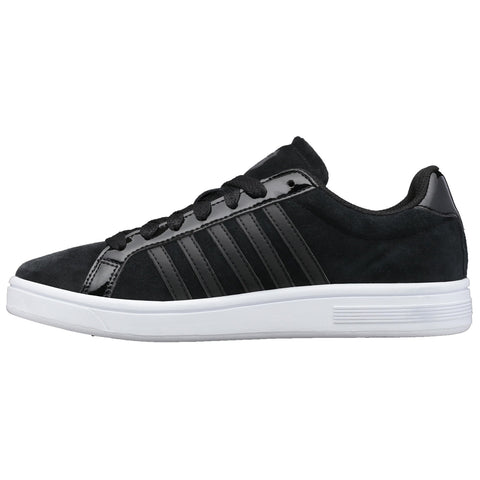 A black sneaker features a smooth upper with glossy stripes and a white sole while positioned on a neutral background showcasing its sleek design intended for casual wear.