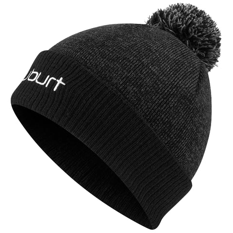 A black knitted beanie hat with a pom-pom on top rests at an angle showcasing its textured fabric and a visible logo embroidered in white on the front