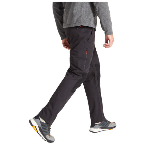 A person is walking wearing dark cargo pants and athletic shoes. They are dressed in a gray long-sleeve shirt, suggesting an active or outdoor environment.