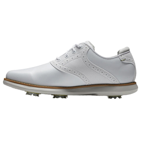 A white golf shoe is positioned on a flat surface displaying a classic design with laces and decorative perforations while featuring soft spikes underneath for traction on the golf course