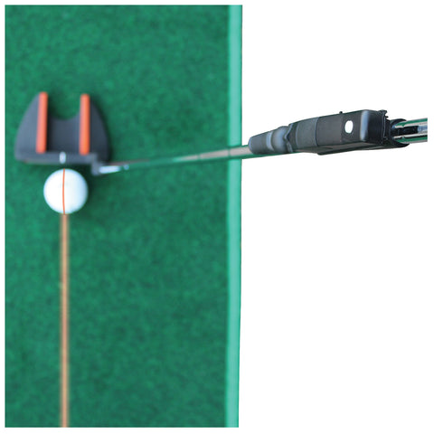 A golf putter is poised above a white golf ball with an orange line, ready to strike it on a green turf surface, indicating a practice or training setting.
