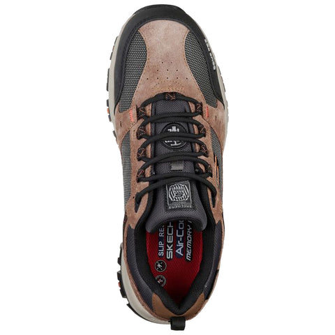 A brown and gray sneaker with black laces is displayed from above. The shoe features a mesh and suede exterior with a red cushioned interior and a sturdy sole.