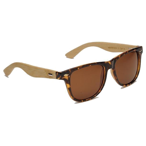 A pair of sunglasses features a tortoiseshell front and light wooden arms and rests on a white surface, designed for sun protection and style.