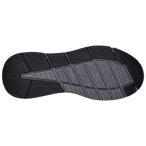 A black shoe sole features various textured patterns for grip. It lies flat on a neutral background, highlighting its design and potential for traction in various environments.
