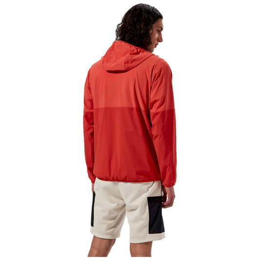 A man wearing a red hooded jacket and light shorts stands with his back turned, showcasing the design in a neutral environment, suggesting a casual or athletic context.