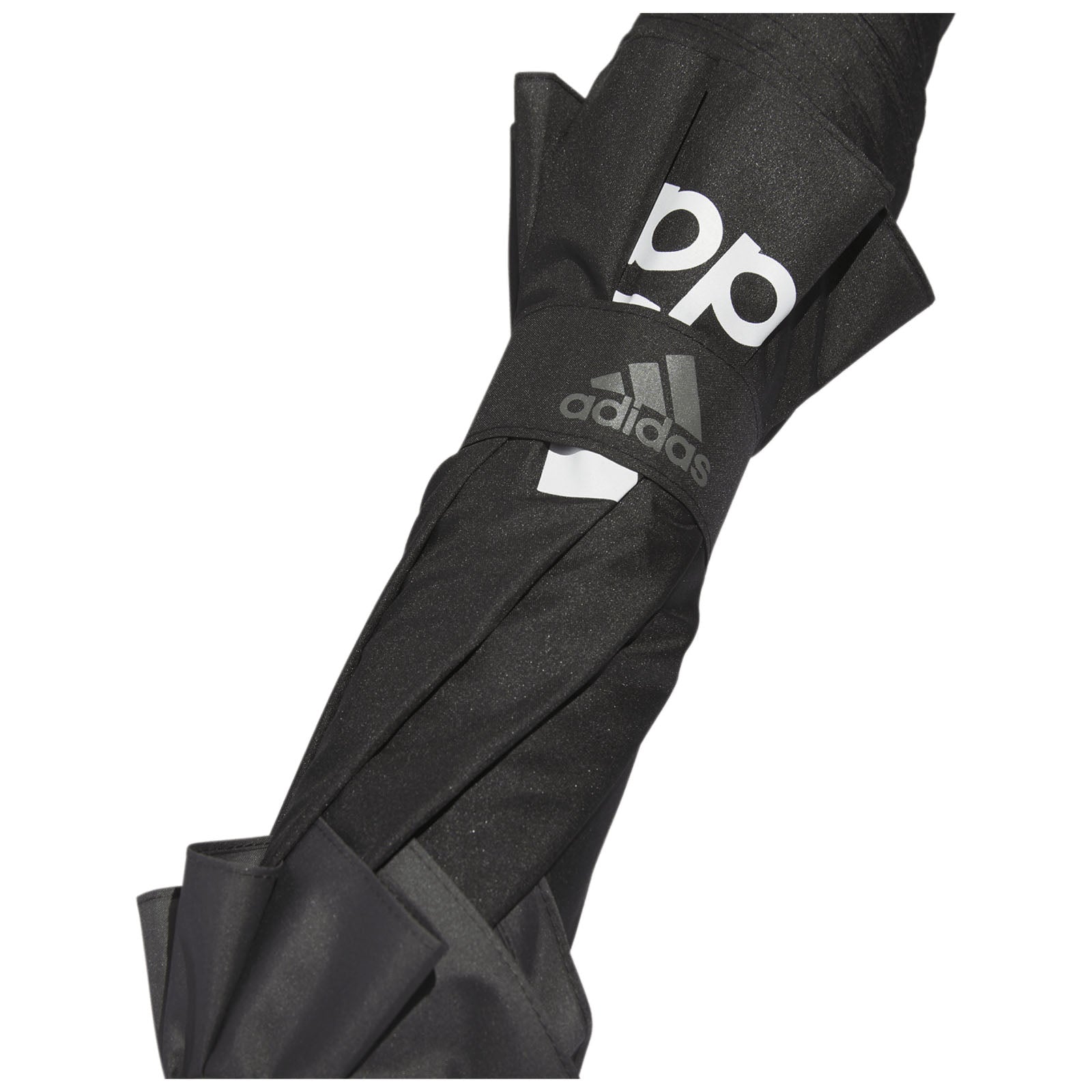 A black umbrella is folded and secured with a strap displaying the word adidas and a logo on its surface suggesting it is designed for protection against rain or sun.