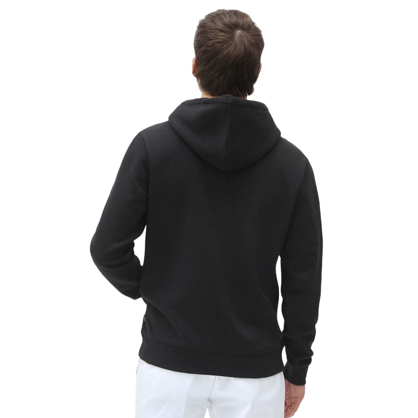 A person wearing a black hoodie faces away while standing. They are in a neutral environment with a plain white background giving focus to the hoodie and the individual's silhouette.
