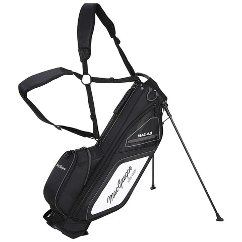 A black and white golf bag equipped with adjustable straps stands upright on its tripod legs with various zippered compartments for storage set against a neutral background.