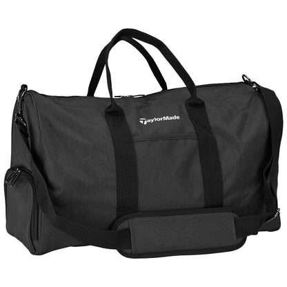 TaylorMade Performance Duffle Bag N8947701 A black duffel bag with double handles and a shoulder strap rests on a flat surface featuring a logo that reads TaylorMade showcasing a sleek design suitable for travel or gym use.