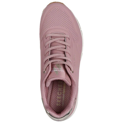 A pink sneaker with a smooth surface and perforated details features a lace-up design. The interior shows a cushioned insole labeled SKECHERS, designed for comfort andstyle.