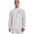 A male model stands confidently wearing a light gray half-zip sweatshirt featuring a small black logo on the chest showcasing athletic wear in a plain light background.