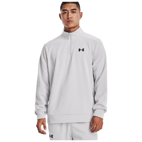 A male model stands confidently wearing a light gray half-zip sweatshirt featuring a small black logo on the chest showcasing athletic wear in a plain light background.