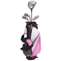 A pink and black golf bag stands upright containing a driver and several irons with a putter attached to the side ready for golf in an outdoor setting.