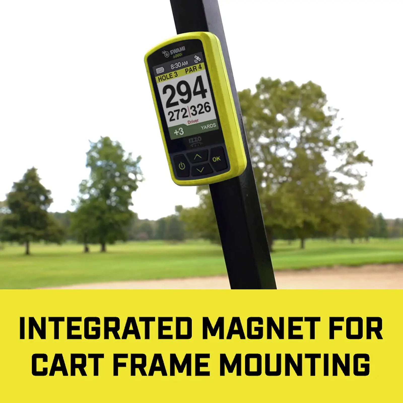 A golf distance measuring device is mounted on a cart frame displaying hole information and yardage amidst a green golf course with trees in the background. INTEGRATED MAGNET FOR CART FRAME MOUNTING
