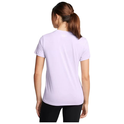 A woman with her back facing the viewer is wearing a light purple athletic shirt and black pants, standing in a neutral setting, suggesting a casual or active environment.