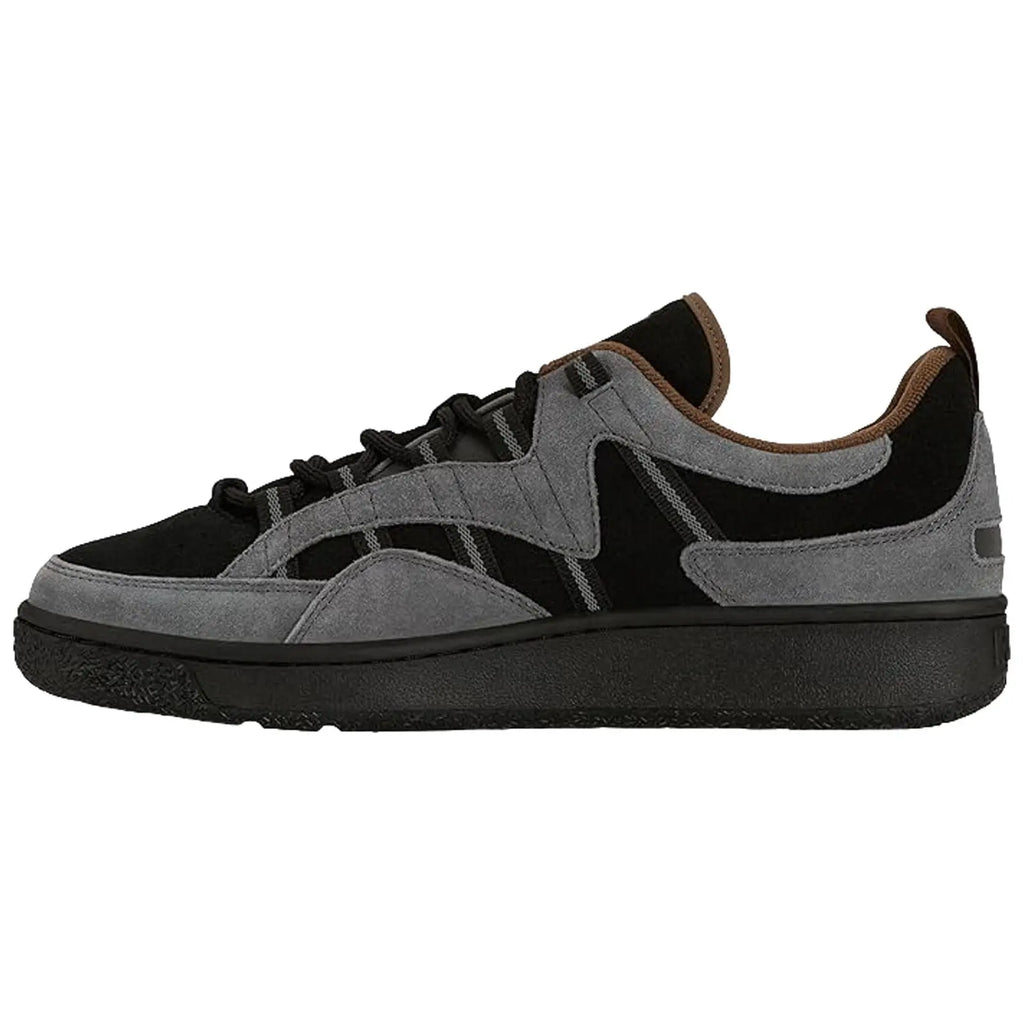 A sneaker features a sleek design with a combination of black and gray suede materials it sits on a dark rubber sole showcasing a casual style suitable for everyday wear