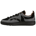 A sneaker features a sleek design with a combination of black and gray suede materials it sits on a dark rubber sole showcasing a casual style suitable for everyday wear