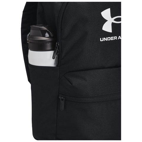 A black backpack features a side pocket holding a white water bottle with a dark cap showcasing the Under Armour logo the backpack is designed for sporty use and convenience.