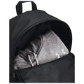 A black backpack contains a gray hooded sweatshirt visible at the opening the sweatshirt has drawstrings and a logo on the sleeve indicating its brand.