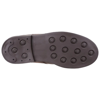 A brown shoe sole is displayed featuring various round studs for traction indicating it is designed for grip on surface likely suitable for sports or outdoor activities.