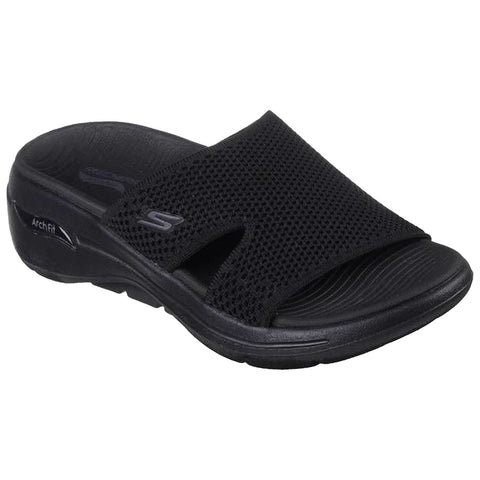 A black sandal featuring a mesh upper and open toe design rests on a flat surface showcasing its lightweight structure suitable for casual wear or indoor use.
