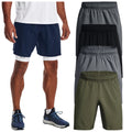 A person stands wearing navy athletic shorts over white compression shorts with blue athletic shoes while four other pairs of shorts in gray black and olive green are displayed nearby.