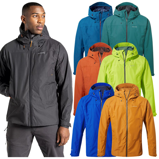 A man is wearing a black waterproof jacket while several colorful jackets in orange green blue and teal are arranged around him showcasing different styles and colors for outdoor wear.