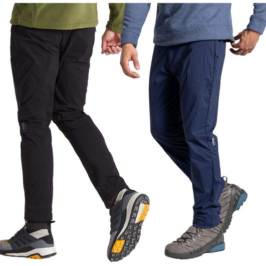 Two pairs of outdoor pants are displayed side by side. One pair is black while the other is navy. Each pair is worn by a person walking, showcasing rugged footwear suitable for hiking.