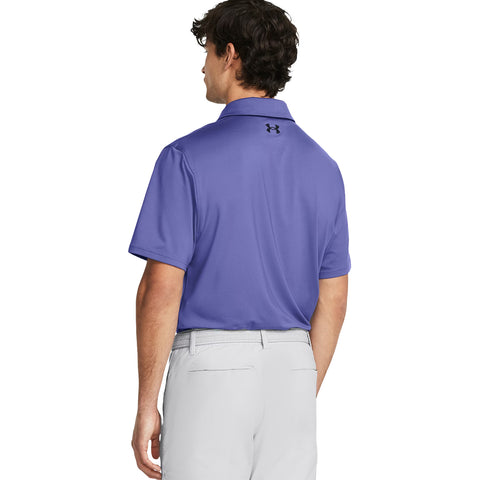 A man is standing with his back facing the viewer wearing a purple polo shirt and light-colored pants in a neutral background emphasizing the clothing and posture.