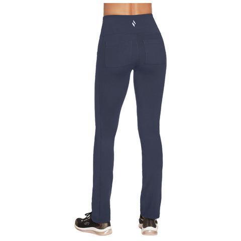 Navy blue leggings are shown from the back with a high waist and two back pockets while being worn with black athletic shoes on a neutral background.