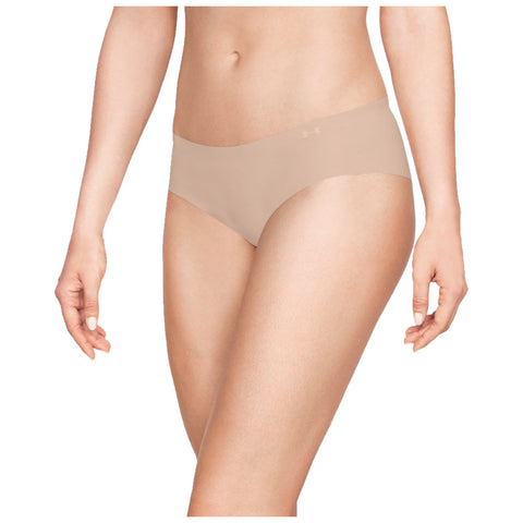 A person is standing and wearing light beige underwear while reaching slightly outward with one hand in a neutral, bright background suggesting a focus on the clothing item.
