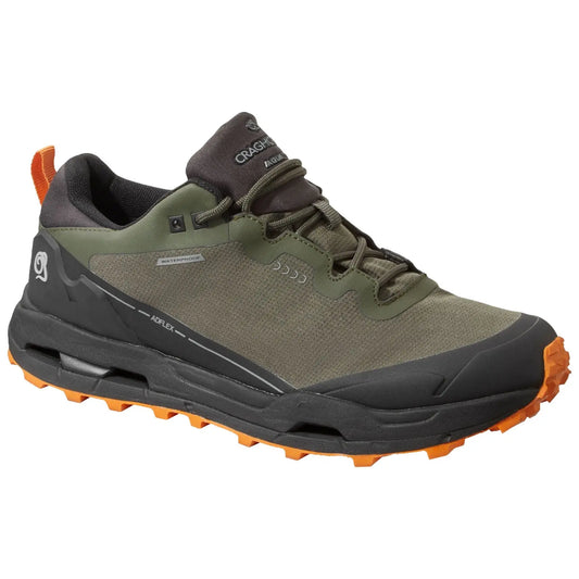 A green waterproof hiking shoe is displayed with a rubber sole featuring orange traction lugs designed for grip on rugged terrain suitable for outdoor activities