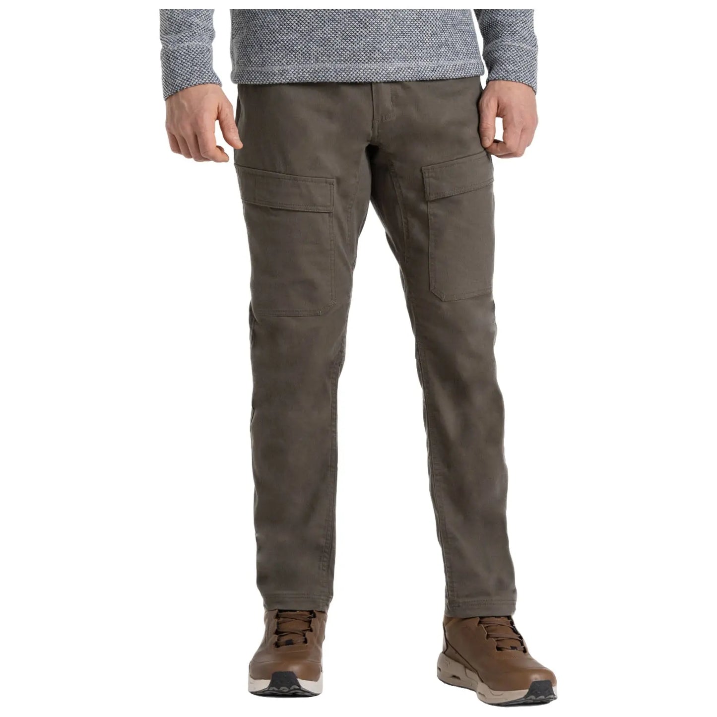A person stands wearing olive green pants with two large side pockets and brown hiking shoes. They are dressed in a long-sleeve gray patterned shirt, presenting a casual outdoor style.
