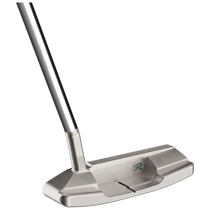 A golf putter rests upright with a metallic silver finish the head is flat and broad featuring a logo on the side and grooves for improved ball contact