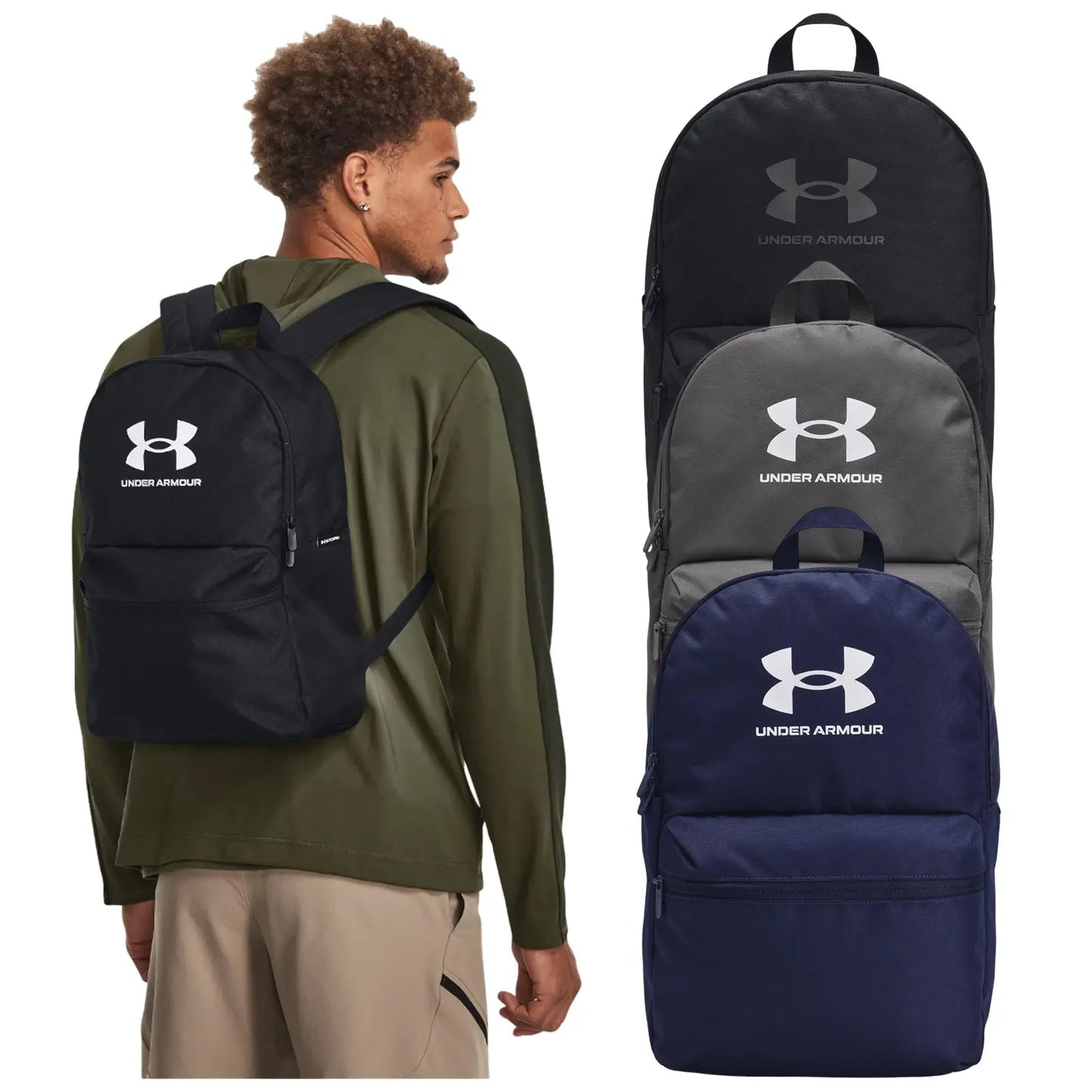 A young man is wearing a black Under Armour backpack while facing slightly away from the viewer. Three additional backpacks in black, grey, and navy are displayed beside him.