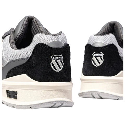 Black and gray athletic shoes are displayed from an angled rear view with a prominent logo on each heel showcasing a stylized shield and brand name K-Swiss on the side.