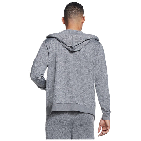 A person is wearing a gray hoodie with a hood pulled down while facing away from the viewer in a casual indoor setting. The outfit appears comfortable and sporty.