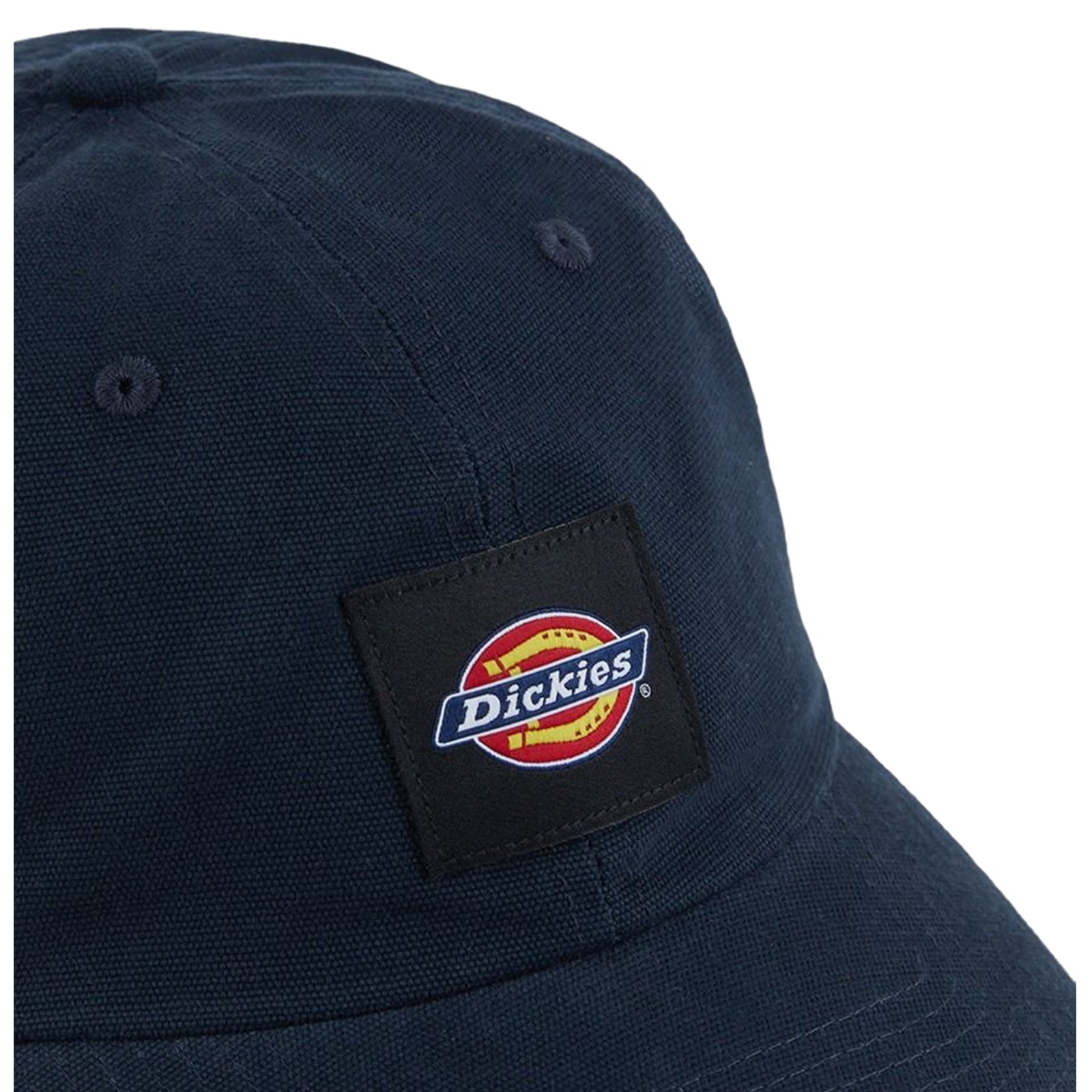 A dark blue cap features a rectangular patch displaying a circular logo with the word Dickies in bold lettering surrounded by red and yellow lines, set against a textured background.