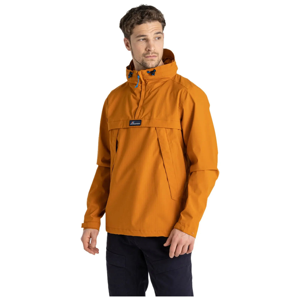 A man wearing an orange jacket stands with a neutral expression. The jacket has a high collar and a front pouch. He is in a plain, lighter background setting.