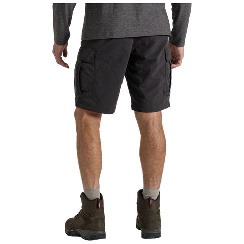 A person is facing away wearing black cargo shorts and hiking boots with gray socks in a casual outdoor setting, suggesting readiness for activities like hiking or exploring.