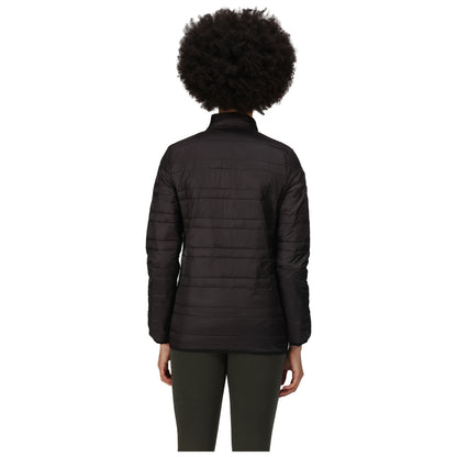 A person is standing with their back to the viewer wearing a black puffer jacket and green pants in a plain white background environment.