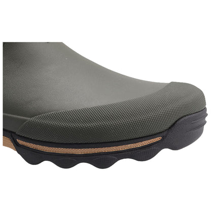 A green rubber boot rests on a surface showcasing its textured toe cap and flexible sole designed for outdoor use in wet conditions.