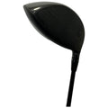 A black golf club driver is positioned upright showcasing its large head and shaft while featuring adjustment settings on the side for customizing performance on the golf course.